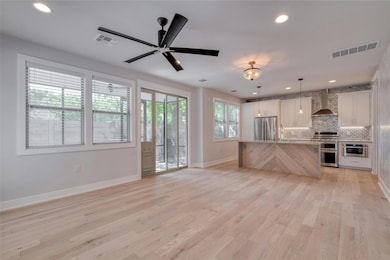 Kitchen with visible vents, open floor plan, wall