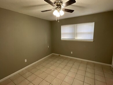 Spare room with light tile patterned floors, ceiling fan, baseboards, and a textured ceiling