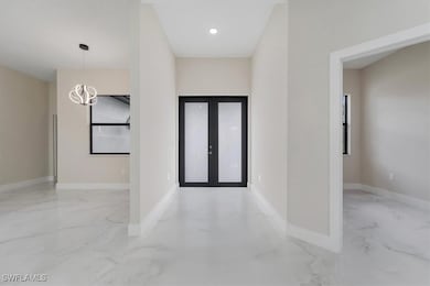 Entryway with marble tiled flooring and a chandeli