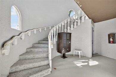 Staircase with a textured wall and finished concrete flooring