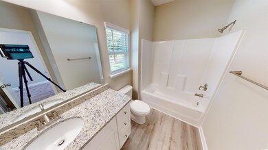 Full bath featuring light wood-type flooring, vanity, and bathtub / shower combination