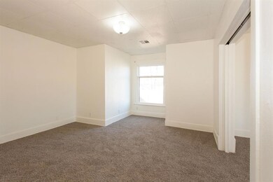 Unfurnished bedroom with carpet floors, baseboards