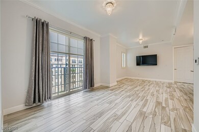 Unfurnished living room with crown molding, healthy amount of natural light, and light wood-style floors