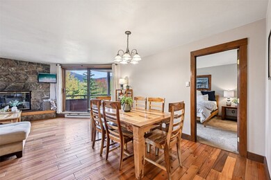 Dining room with light wood-style flooring, a fireplace, and a chandelier