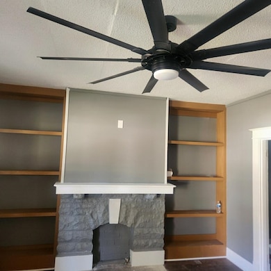 Interior space with a textured ceiling, a stone fi