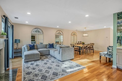 Living area with light wood-style floors, recessed lighting, and a fireplace with flush hearth
