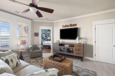 Living area with crown molding, wood finished flo
