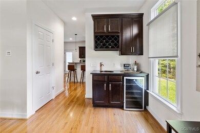 Bar with beverage cooler, light wood-style floors,