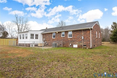 Rear view of property featuring crawl space and brick siding