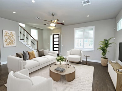 Living room with recessed lighting, dark wood-type flooring, a ceiling fan, and stairs