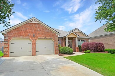 View of front of house featuring brick siding, driveway, an attached garage, and a front lawn