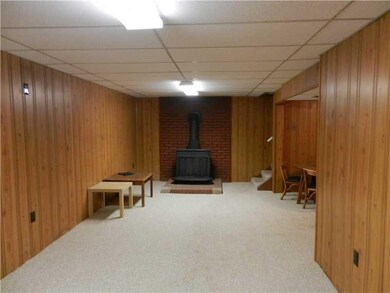 Family Room. HUGE LOWER LEVEL FAMILY ROOM WITH WALL TO WALL CARPET, WOOD BURNING STOVE. ADJACENT IS FUL BATH, DEN AREA AND FULL BATH