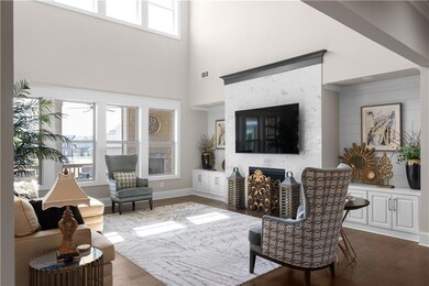 Living area with a high ceiling, a warm lit firepl