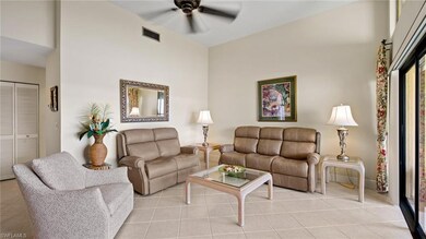 Living room featuring a ceiling fan, light tile patterned flooring, high vaulted ceiling, and baseboards