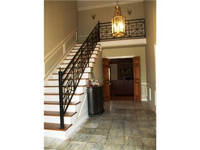 Gorgeous foyer with marble floors, iron railings a