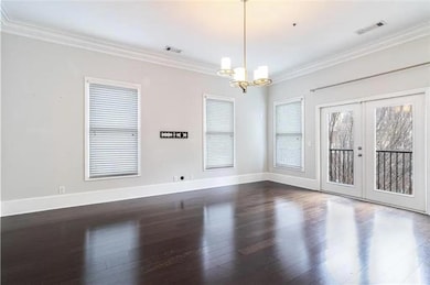 Spare room featuring a chandelier, french doors, d