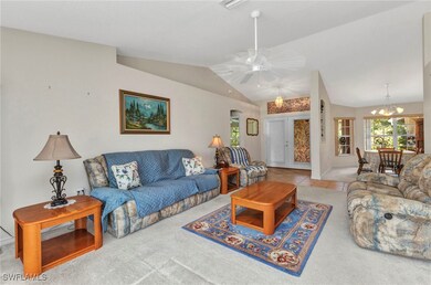 Living room featuring lofted ceiling, a ceiling fa