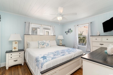 Bedroom with dark wood-type flooring, ceiling fan,