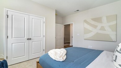 Bedroom featuring light colored carpet and a close