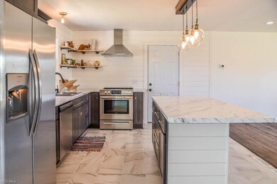 The kitchen has stainless steel appliances and ope