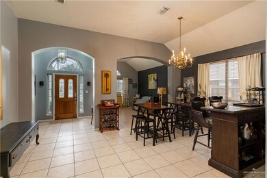 Formal living room, Dining area featuring lofted ceiling, an inviting chandelier, and light tile floors
