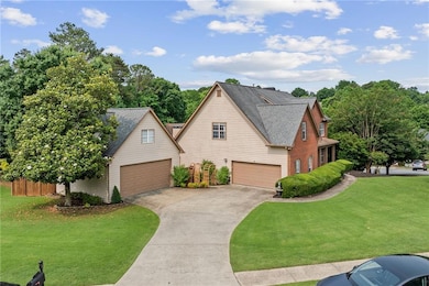 Traditional home featuring concrete driveway, a shingled roof, and an attached garage
