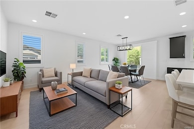 Open living and dining space leading to a serene, entertainer’s backyard, with rolling shutters covering the slider (virtually staged)