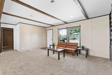 Living room featuring beam ceiling and carpet floo