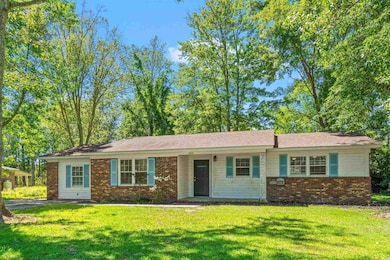 Single story home with a front lawn and brick siding