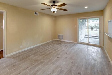 From the formals in the front of the house you enter a large family area just off the kitchen and entrance to the back covered patio area.  New sliding glass doors have been added.
