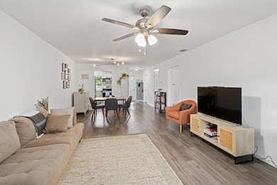 Living room with ceiling fan and wood finished fl