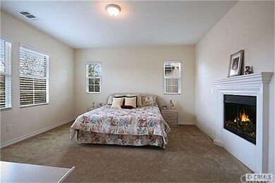 Open airy master bedroom with a fireplace for thos