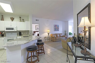 Kitchen with white appliances, a sink, light tile