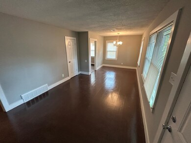 Empty room featuring dark wood-type flooring, a te