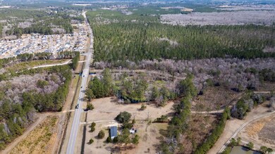 Aerial view of property and surrounding area with a forest