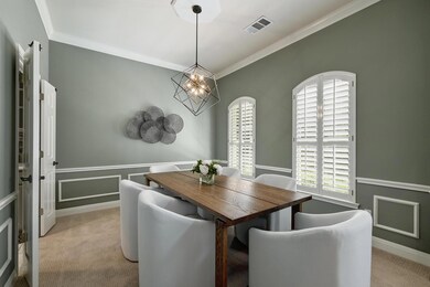 The formal dining room exudes elegance with its crown molding and traditional design elements.
