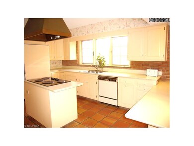The kitchen features a brick accent wall, copper r