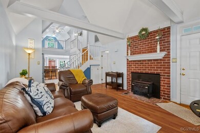 Living room with a brick fireplace, hardwood / woo