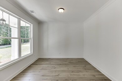 Unfurnished room featuring visible vents, baseboar