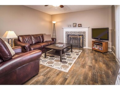 Living room features cozy wood fireplace with new 
