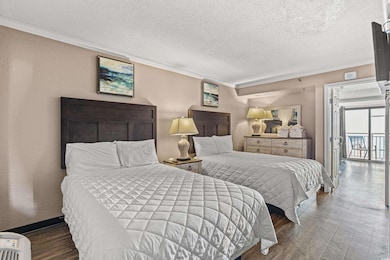 Bedroom featuring a textured ceiling, crown molding, and access to exterior