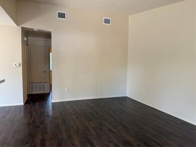 Spare room featuring dark wood-style flooring, ba