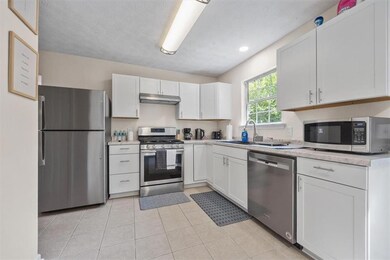 Kitchen featuring a textured ceiling, light tile p