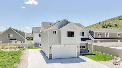 View of front of property with board and batten siding, stone siding, an attached garage, concrete driveway, and roof with shingles