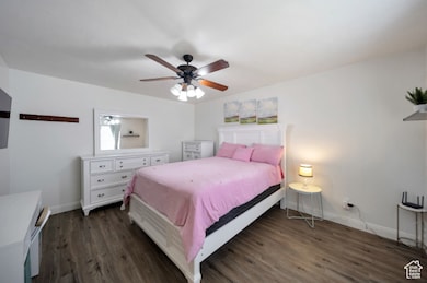 Bedroom with dark wood finished floors and a ceiling fan