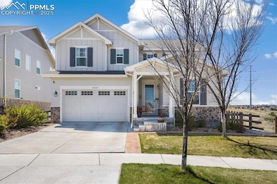 Craftsman-style house with concrete driveway, ston