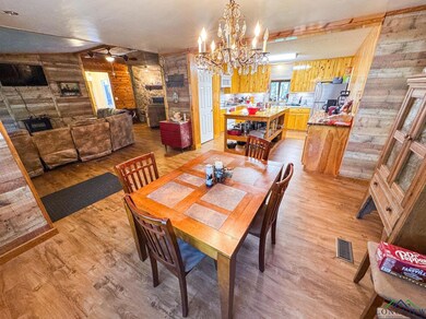 Dining room featuring wooden walls, light wood-type flooring, and a chandelier