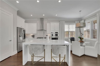 Kitchen featuring wall chimney exhaust hood, stain