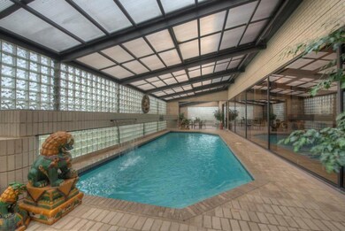 Indoor in-ground pool and patio with waterfall and