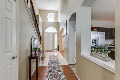 Entryway with a high ceiling, ceramic tile and laminate wood floors.